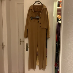 Kamelfärgat byxset NA-KD, strl 36 - Kostymbyxor med matchade jacka, ”kamelfärgat”/mörkt beige. Storlek 36. 