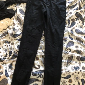Kostymbyxor med slits - Ett par svarta kostymbyxor med slits nere vid ankeln. Sitter perfekt i längden på mig som är 1,75 cm. De är strl 38 och inte så stretch. Säljer de då kvittot är borttappat