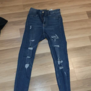 Blåa jeans  - Mörkblåa jeans med slitna hål