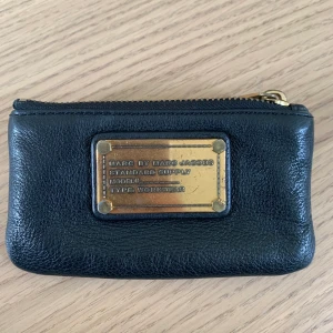 Marc Jacobs  - Säljer en Marc By Marc Jacobs plånbok/portmonnä. Skinnet är som nytt men guldplattan är sliten. Perfekt som plånbok eller lägga sina nycklar i. Pris + frakt. 