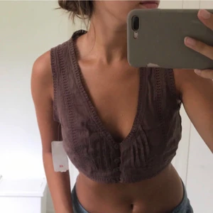 Kort brun topp med Storlek 36 - Söt topp med färgen mörk brun. Olika fina detaljer bland annat knappar på framsidan. Storleken är 36. Toppen är helt oanvänd med etiketten kvar. 