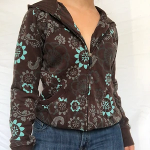 Kofta - BUD ENDAST GILTIGT OM MAN ÄVEN SKRIVIT PRIVAT! Brun kofta med underbart blått blommigt mönster. Stor huva. Visas på en s men passar storlekar mellan xs-m beroende på önskad passform. Märkt storlek 36-38. Passar bra t jeans men även till mycket annat pga de neutrala färgerna. Köpare står för 66kr frakt. Gott defetfritt skick.