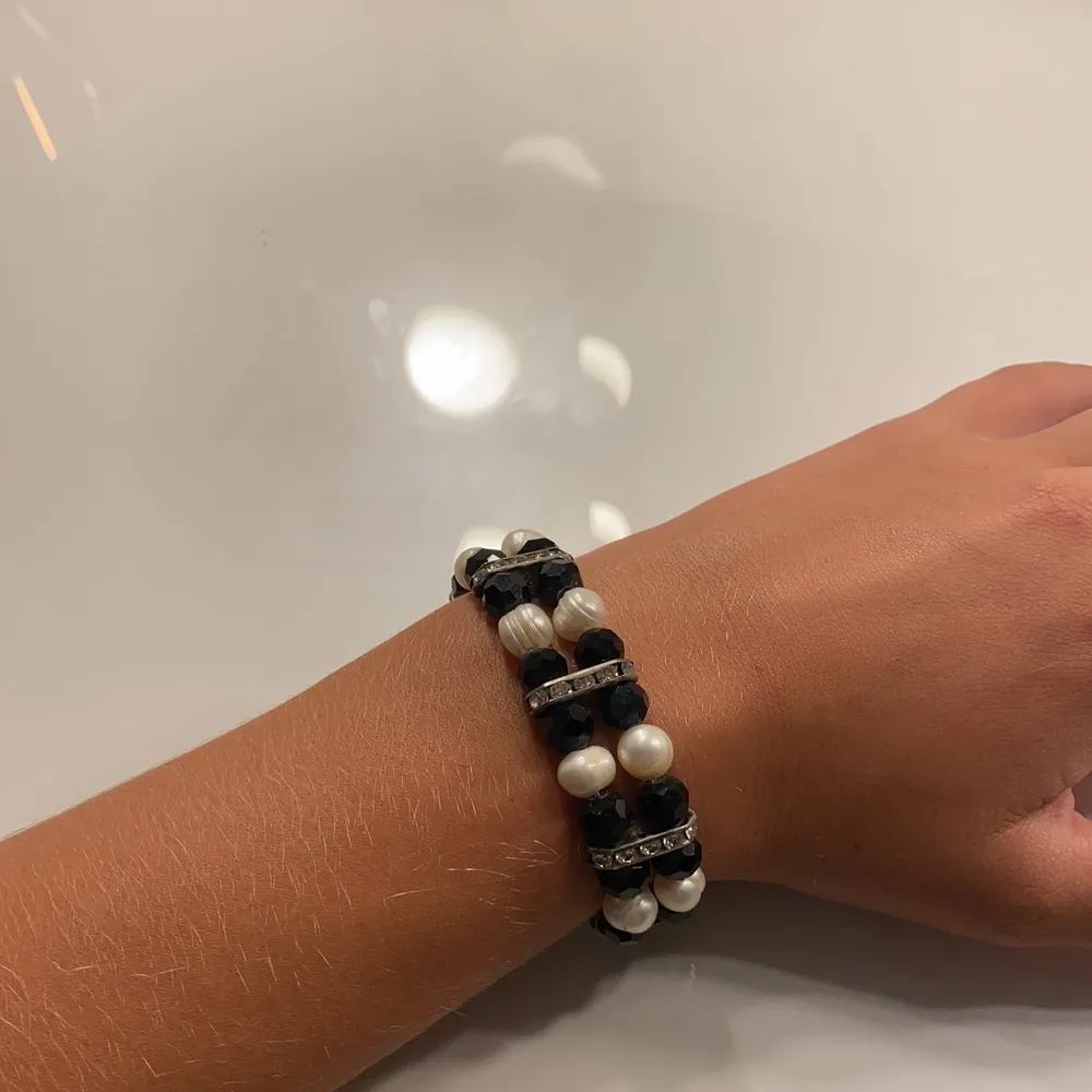 Ett armband med vita och svarta pärlor med diamanter som är jätte fint och stretch bart. Accessoarer.