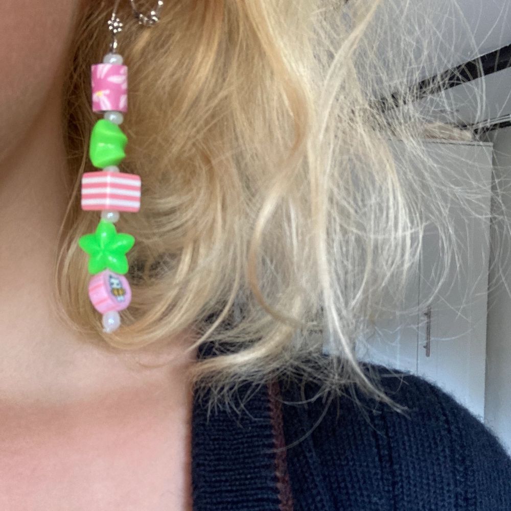 Jättegulliga, handgjorda örhängen med rosa och gröna pärlor i plast. Pärlan längst ner har ett kattmotiv och kroken en liten blomma. 8cm långa, inte alls tunga. . Accessoarer.