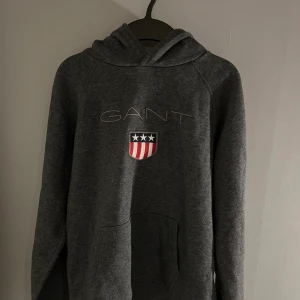 Gant huvtröja Shield logo, (mörkgrå) - Är i nyskick och knappt använd och har endast tvättats två/tre gånger, har inga fel eller skavanker.