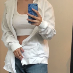 Vit rebook hoodie med dragkedja  - Denna zip hoodie är i bra skick och väldigt bekväm. Passar till allt! Säljes då jag har en annan liknande 