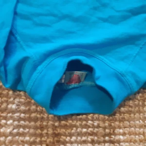 Retro sweatshirt turkos blå 90s - RETRO SWEATSHIRT typ oanvänd med hög krage i turkosblå färg. Ganska liten men kan passa en liten person. Skulle tippa att den är från 90 talet