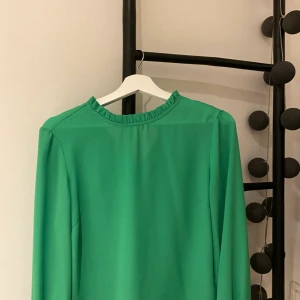 Grön blus - Fin grön blus, detaljer vid kragen och armarna. I väldigt fint skick! Köparen står för frakten.