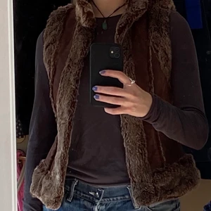 Väst - Jättesnygg läderväst med pälsdetaljer köpt second hand men i väldigt bra skick✨ 🪐 den har spännen längs hela öppningen så man kan stänga den om man vill❣️ det är päls även på insidan så den värmer väldigt bra🥰 helt oanvänd med prislappen kvar, köpt för 450kr. (Är rätt säker på att det är fejkpäls)