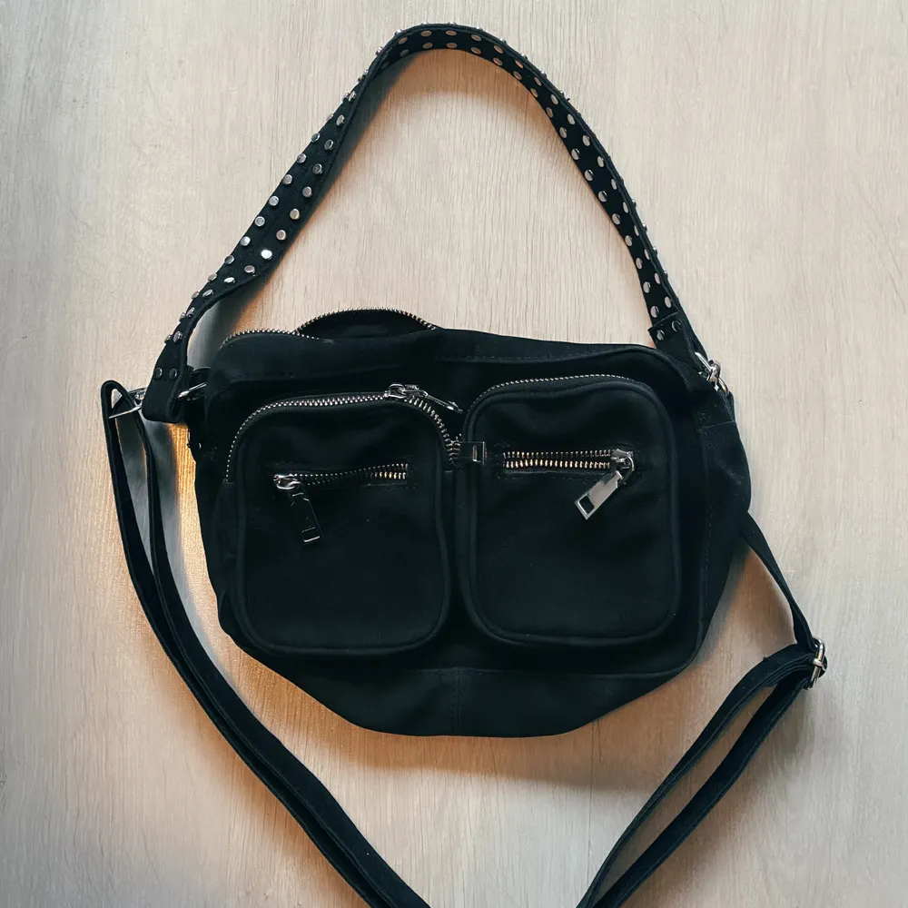 Rymlig fin väska från Noella, knappt använd.                   Har två band, ett kort med nitar och ett längre justerbart crossbody-band. Köparen betalar frakt.                                          Nypris 700kr, men säljer för 150kr. Väskor.