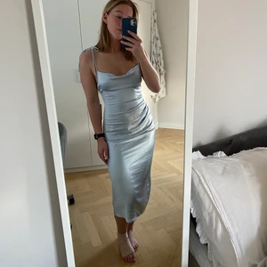 Ljusblå silkesklänning från nakd - Säljer denna ursnygga silkesklänning från Hanna schönbergs kollektion ihop med NAKD. Den är aldrig använd med etiketterna kvar. Storleken är 36.  Frakt tillkommer om inget annat är överenskommet ☺️