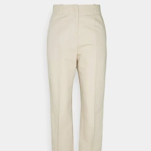 Hugo Boss Tygbyxor - Ett par skitsnygga beiga tygbyxor från Hugo Boss I storleken 38. Perfekt till finare byxor men även vardag! Använd bara ett fåtal gånger men är i nyskick! Är lite för små på mig därför säljer jag dom...:( Går att använda året om! Har bra längd i benen och finns öglor till skärp🤩🥰                             (Nypris 1700kr)