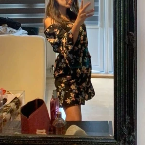 Sommarklänning - En väldigt fin sommar klänning som köptes i H&M. Den är offshoulder och formar midjan. Längst ner på klänning och även på ärmarna finns det volanger. Storlek 34