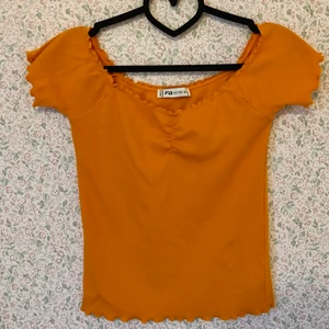 Offshoulder-tröja  - Fin offshoulder-tröja med fina sömdetaljer. Svårt att få rätt färg på bild men tröjan är mycket finare och klarare orange i verkligheten. Storlek XL men känns mer som en M eller L. 