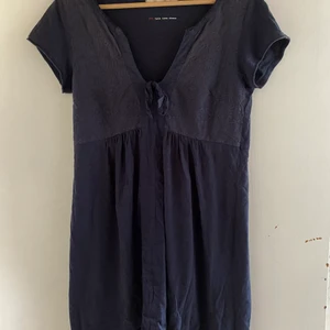 Oddmolly Klänning ”lets love dress” - En super söt marinblå klänning i t-shorts material. Använd ett fåtal ggr. Har en fint mönster på bysten med två band som är knutna som en rosett. Den är i storlek S. Själv är jag 165 cm och den går precis över knäna. Den är i t-shorts material så den är super skön. Nypris 800kr
