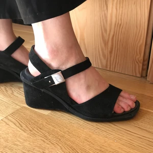 Billiga sandaler - Svarta sandaler med spänne och kilklack! Säljer billigt. Står storlek 41 men skulle säga att de passar en 39a-40 bättre.