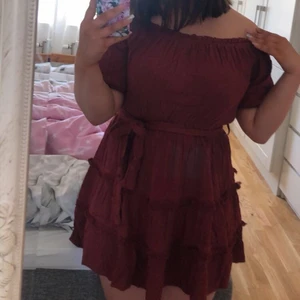 Off shoulder klänning från asos  - Supersnygg och somrig vinröd klänning från Asos. Klänningen är off shoulder samt har ett resårband vid överdelen och i midjan. Det finns ett band att knyta snyggt runt midjan. Klänningen är använd endast engång och är i bra skick! 
