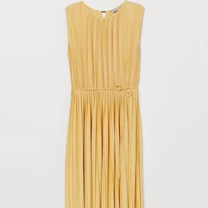 Ny sommarklänning/ gul plisserad klänning  - En knälång klänning i plisserad trikå med lyster. Rundad halsringning och v-ringad öppning bak med stavpärla i nacken. Avskuren i midjan med resår,  avtagbart knytband. Stl L, mycket fint skick. Endast använd 2 gånger. 100 % polyester, normal i storleken.