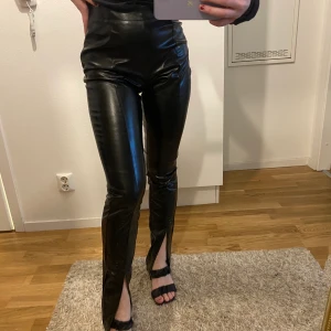 Skinnbyxor med slits  - Supersnygga skinnbyxor med slits fram till i strl S. Aldrig använda. Säljes pga förstora. Mycket fint skick 