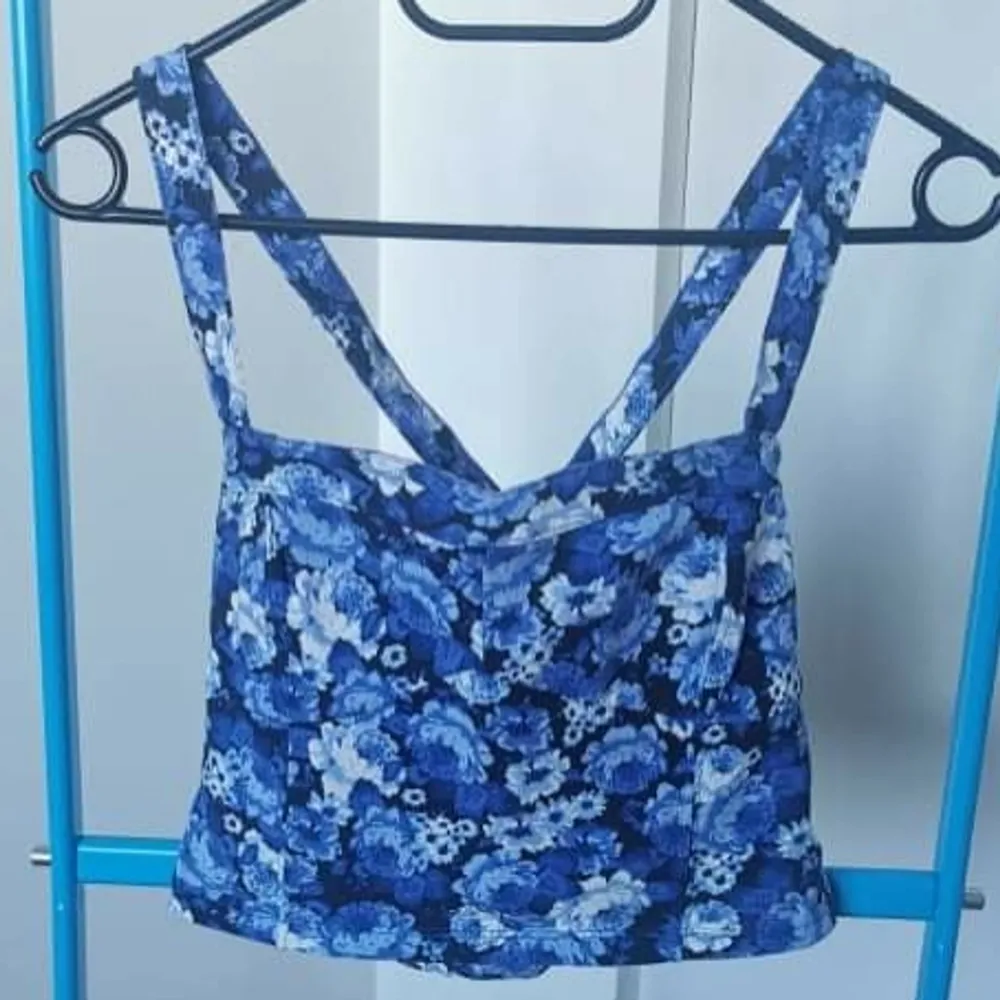 SafirBlå crop top med blommig detalj och korsad ryggband, perfekt inför sommaren!. Toppar.