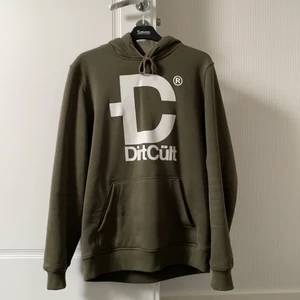 En militär grön Dirtcult tröja med luva.  - Den är unisex. Storlek M.