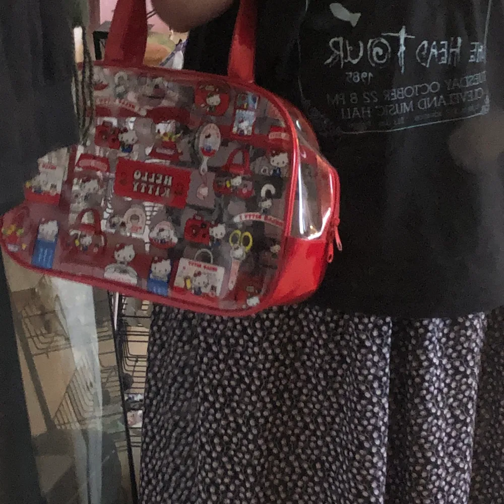 En röd och genomskinlig hello kitty väska från kawaii shop!!! Använt ändats ett par få gånger!. Väskor.
