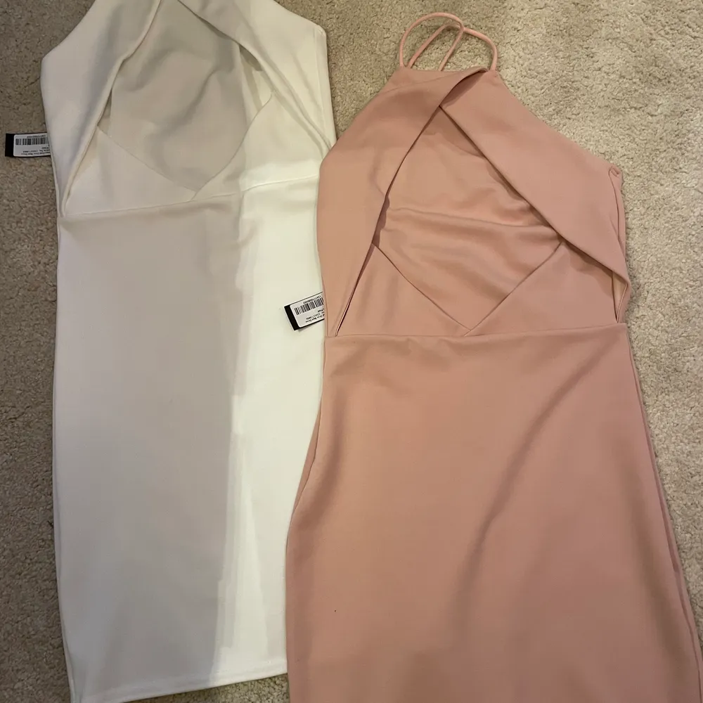 Två jättefina oanvända halterneck/fodralklänningar från NELLY.com. Lappar finns kvar på båda klänningar. Strl XS/34. 50kr styck eller båda för 80kr. (OBS! Den vita är såld). Klänningar.