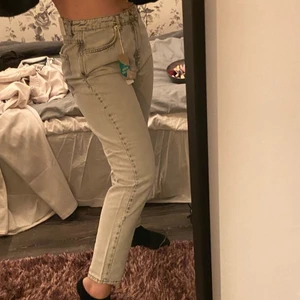 Ljusgråa mom jeans från Ginatricot i storlek 42 - Prislapp kvar aldrig använda, ljusgråa mom jeans från gina! Skulle säga att dem passar en S/M beroende på vad man vill ha för passform!