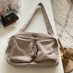 Snygg väska från Gina i beige färg  - Oanvänd väska från Ginatricot i grå färg som inte säljs längre. Ska likna noella väskan eller nunoo bag. Fin i skick. 