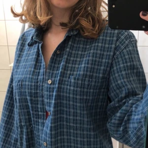 Skjorta - En blårutig skjorta som är använd ett fåtal gånger.