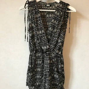 Svart mönstrad playsuit, XS - Så härlig byxdress! Svart med vitt mönster. Denna har något slags sidenaktigt tyg. Mkt skönt när solen skiner!  S eller XS.  Kan mötas i Stockholm eller skicka mot fraktkostnad! ✨🌸✨