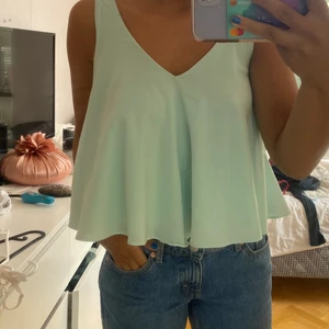 Turkos topp  - Turkos topp med lite volang där nere. Storlek s. 65kr plus frakt på 50. Vet ej var den är ifrån.