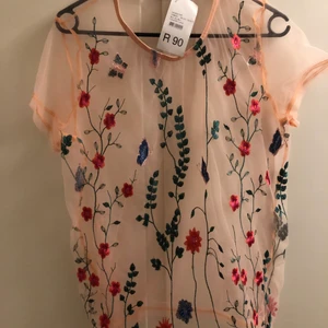 Rosa genomskinlig blommig T-shirt  - NY aldrig använd, Rosa genomskinlig ”T-shirt” med blommor, köpt utomlands. 