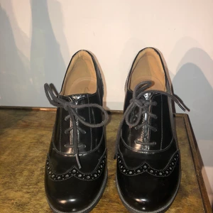 Svarta lack klackar - Svarta klackar storlek 36 från Clarks. Använda 1 gång och syns inte i sulan att de är använda. Klacken är 7cm och lagom bred. Begagnade när jag köpte de då de var för små för henne. Köparen står för eventuell frakt😊