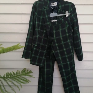 Kostymset från NA-KD - Kostym (byxor strl 34, kavaj strl 36) från NA-KD i mörkblå och gröna rutor. Skitball till hösten, tillsammans eller separat. Normala i storlek, men man kan även ha kavajen om man är strl 38. Väldigt bra skick Koch skönt material. Säljes helst inte separat, men kan förhandla. Säljer då byxorna blivit för små (jag är mer en 38). Går inte längre att hitta på hemsidan så passa passa på att fynda!! 