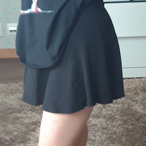 Svart kjol - En svart mjuk kortkjol, bommul. Har tyvärr klippt bort lapparna. Resår i midjan.