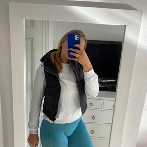 Svart dunväst - Säljer denna supersöta svarta dunväst med luva!💞 Barnstorlek 140/150 men sitter jättesnyggt om man vill ha den kortare. (Jag har vanligtvis S/M)❣️Två rymliga öppna fickor och en fungerande dragkedja💕