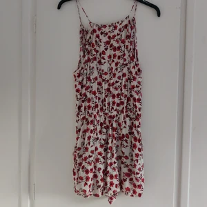 Blommig Playsuit  - Superfin Playsuit med halter och öppen rygg. Plagget har även två fickor och resor i midjan för att skapa en snygg passform. Fint skick och säljer tyvärr för att den är för liten för mig🌸 Kan mötas upp i Uppsala alt skicka mot att köparen står för frakt