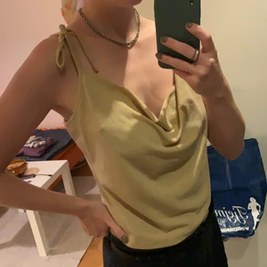 Topp - Guldglittrig topp med band som kan regleras med att knyta en rosett. Storlek M 