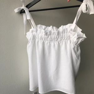 Vit topp med knytning  - Helt oanvända linne från h&m 🤍🤍   Passar de flesta storlekar eftersom man knyter längden själv vid axlarna.  Frakten kostar 45kr 📦  
