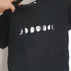 En svart tshirt med månfaser. Oanvänd