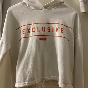 Vit hoodie med snöre ner till - En vit tröja med orange text på i bra skick 