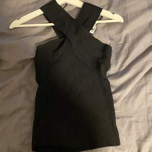 Supertrendigt svart ribbat linne som är korsat i halsen från Zara. Använt en gång💘💘