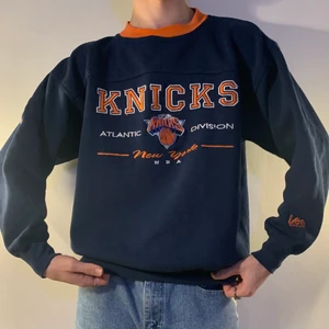 Vintage mörkblå orange sweatshirt Knicks - Mörkblå vintage Knicks sweatshirt med orangea, vita och blåa broderade text- och basket detaljer på bröstet i olika sjukt snygga fonter samt orange Lee brodyr på vänster arm och en blå, vit och röd NBA patch på höger överarm 🏀 Jag älskar att tröjan har en oversized fit men sitter perfekt vid handlederna och halsen! Alla små broderade detaljer GÖR verkligen tröjan! Så snygg till vanliga jeans och sneakers för en chill outfit som aldrig kan gå fel!