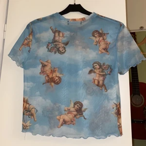 Super söt mesh tröja med änglar  - Säljer denna super söta blåa mesh tröjan med änglar på! Hur fin nu till våren / sommaren?! Köpt på Behrska i Barcelona och är som ny!🦋🦋 Den är i storlek L men liten i storleken. Passar mig som är S/M, skulle säga att den passar XS-M beroende på hur man vill att den ska sitta! Hör av dig för frågor eller fler bilder❣️