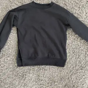 En svart sweatshirt med slits. Storlek Xs