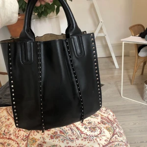 Väska - Svart väska med gulddetaljer från zara! Rymlig och reglerbart axelband medföljer. Fint skick! Pris kan diskuteras😊