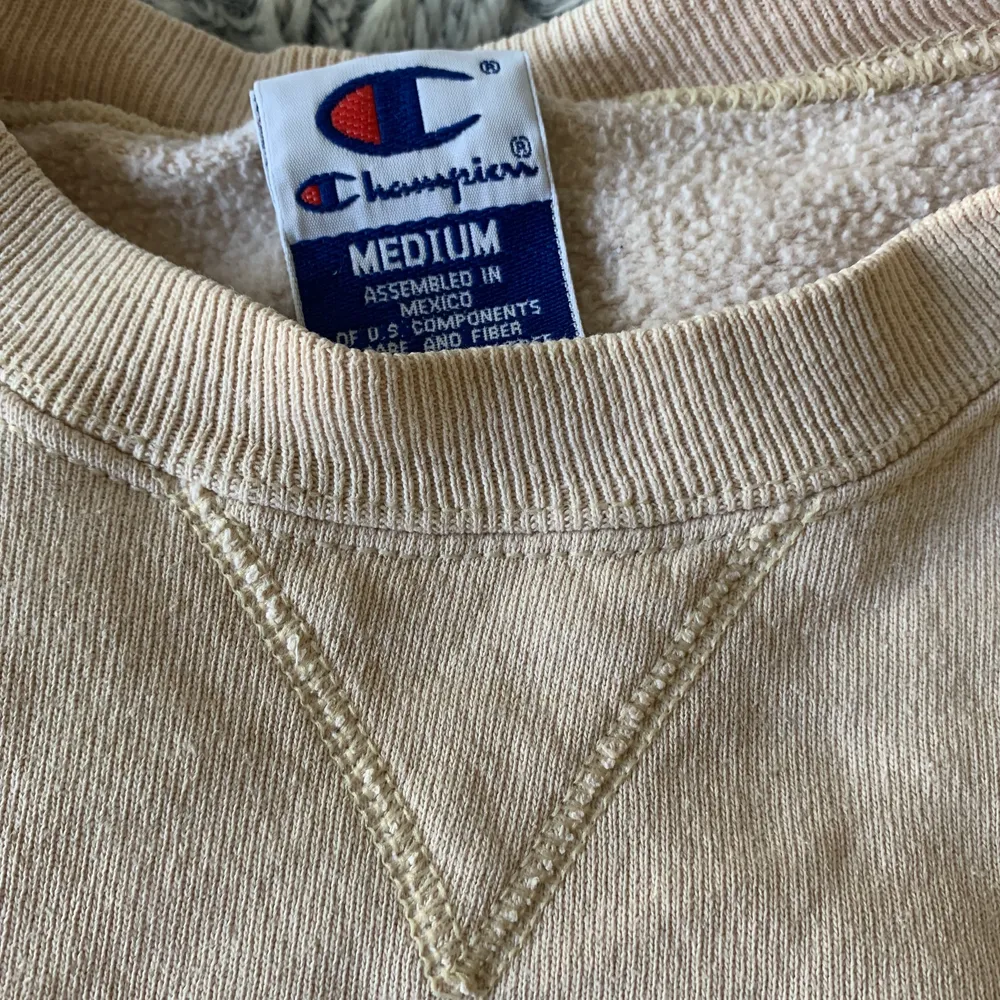 En beige champion collegetröja med mörklila detaljer i storlek M, men väldigt liten för att vara M, skulle säga S. . Hoodies.