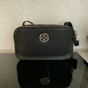 Svart väska från Åhlens - Svart axelremsväska från Åhlens! Använt sällan, men sjukt stilren och enkel att passa till en outfit ❣️