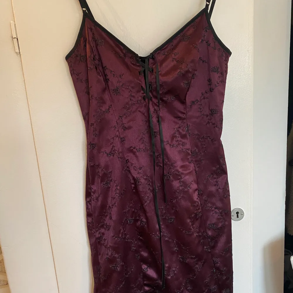 En mörklila klänning köpt från humana för 2 månader sedan. Mycket bra skick och aldrig använd av mig. Märket är franskt,des filles à la vanille Paris. Slutar precis ovanför/vid knäna. Svarta blomdetaljer som glittrar, och man kan spänna snöret vid bröstet. Står ingen storlek men passar mig som är XS. Nypris 150kr. Superfin!. Mekot.